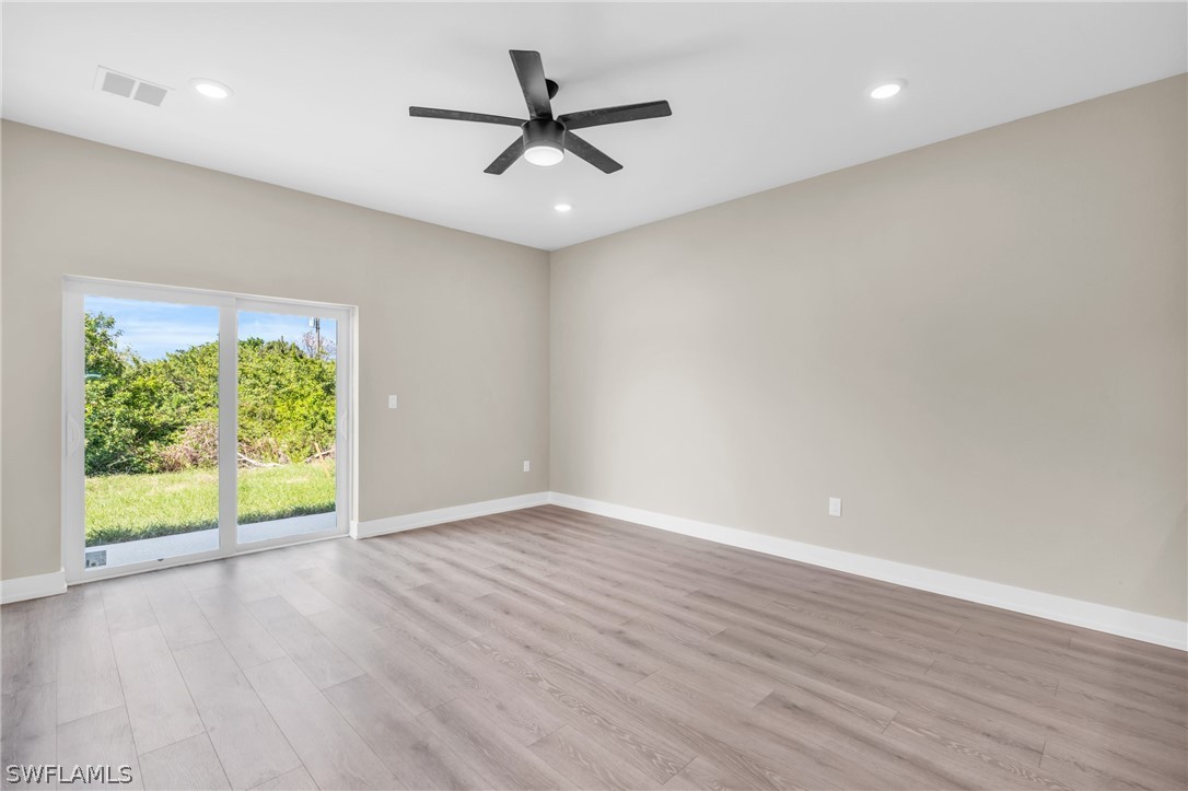 12208 Tetzel Avenue Port Charlotte, FL 33981 - Photo 30 of 45 an empty room with wooden floor and windows