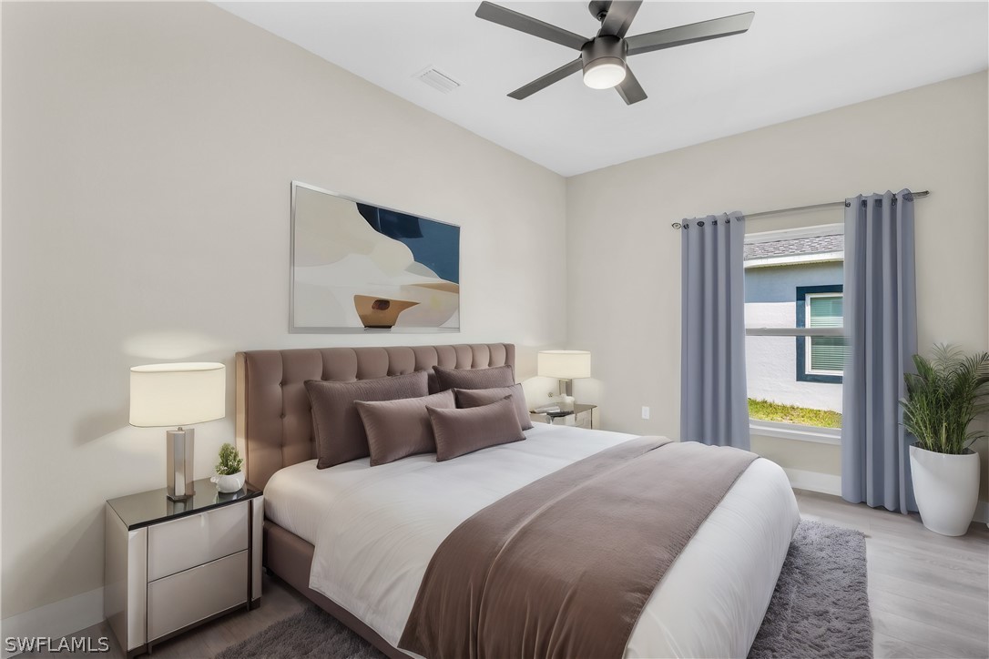 12208 Tetzel Avenue Port Charlotte, FL 33981 - Photo 4 of 45 a bedroom with a bed and a chandelier