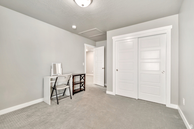 3232 West 1670th Street North Provo, UT 84601 - Photo 22 of 33 Bedroom with light colored carpet, a closet, and a textured ceiling