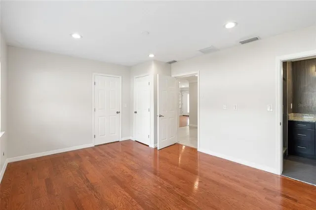 a view of empty room with wooden floor