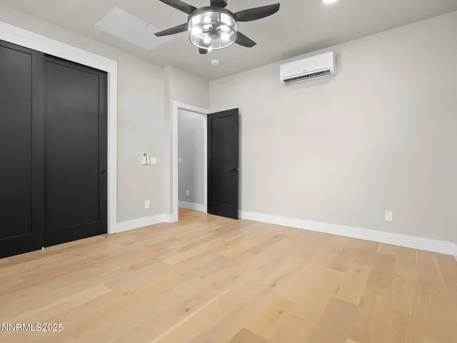 a view of an empty room with chandelier fan