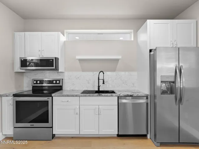 a kitchen with stainless steel appliances granite countertop a sink stove and refrigerator