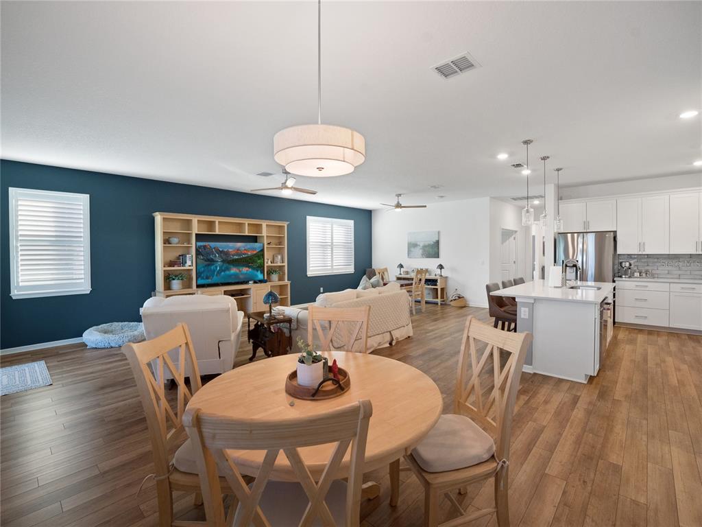 8741 Southwest 61st Loop Ocala, FL 34481 - Photo 17 of 60 a view of a dining room with furniture wooden floor and chandelier