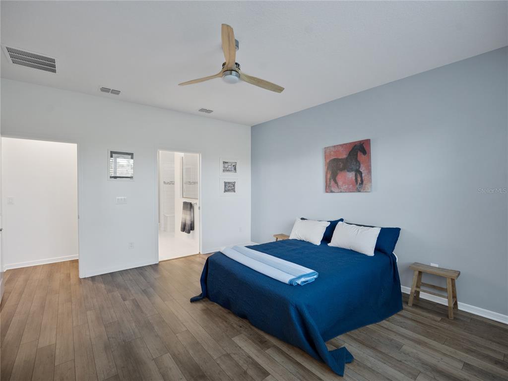 8741 Southwest 61st Loop Ocala, FL 34481 - Photo 19 of 60 a bed room with a bed and a chandelier