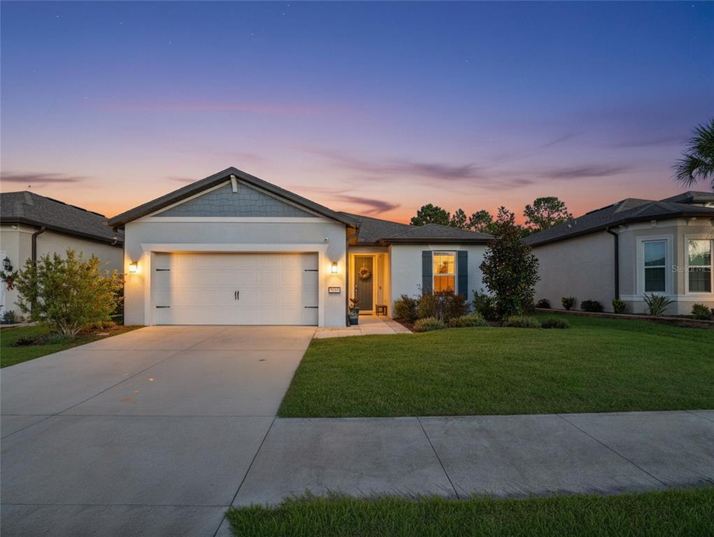 8741 Southwest 61st Loop Ocala, FL 34481 - Photo 2 of 60 a front view of a house with a yard and garage