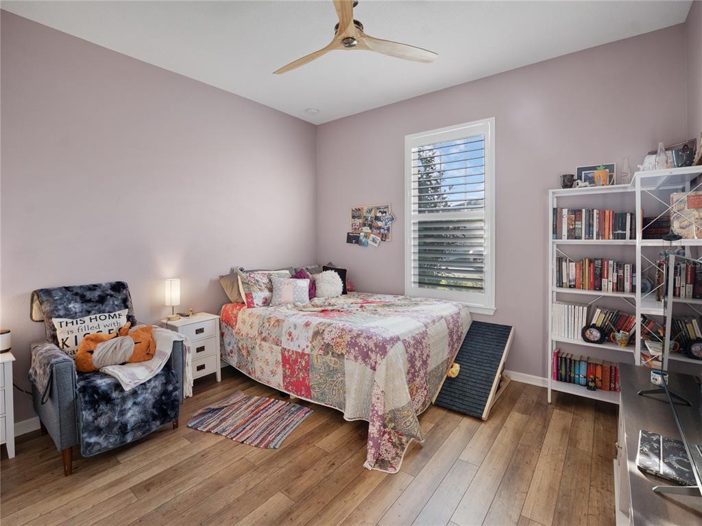 8741 Southwest 61st Loop Ocala, FL 34481 - Photo 22 of 60 a bedroom with furniture and a book shelf