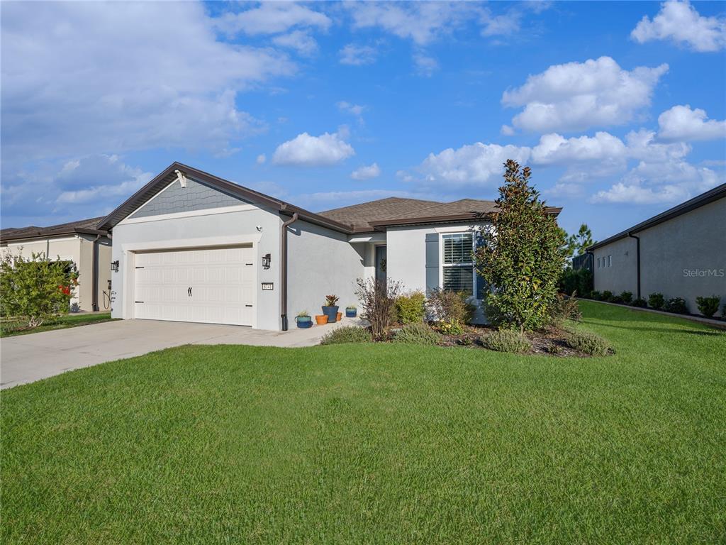 8741 Southwest 61st Loop Ocala, FL 34481 - Photo 37 of 60 a front view of a house with a yard and garage