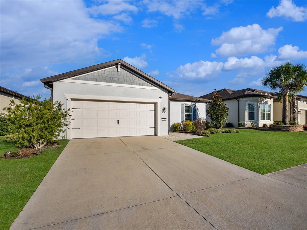 8741 Southwest 61st Loop Ocala, FL 34481 - Photo 39 of 60 a front view of a house with a yard and garage