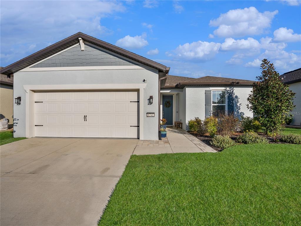 8741 Southwest 61st Loop Ocala, FL 34481 - Photo 40 of 60 a front view of a house with a yard and garage