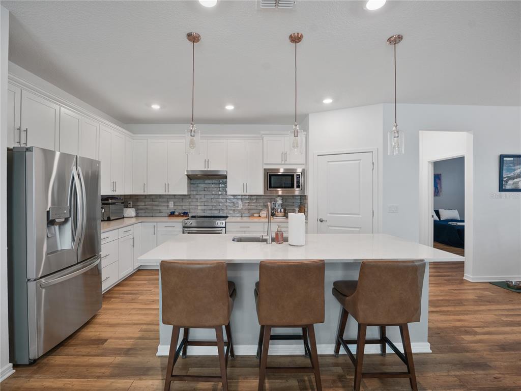 8741 Southwest 61st Loop Ocala, FL 34481 - Photo 9 of 60 a kitchen with stainless steel appliances granite countertop a sink a stove a refrigerator with a dining table and chairs