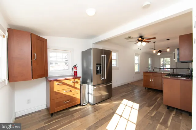 a large kitchen with stainless steel appliances kitchen island granite countertop a refrigerator and a stove