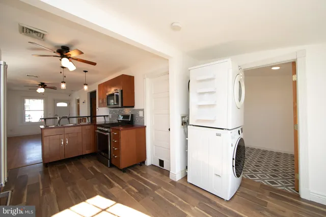 a kitchen with a refrigerator a stove top oven a sink and dishwasher with wooden floor