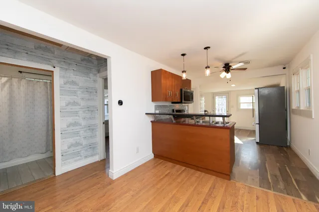 a view of kitchen with kitchen island wooden floor and refrigerator