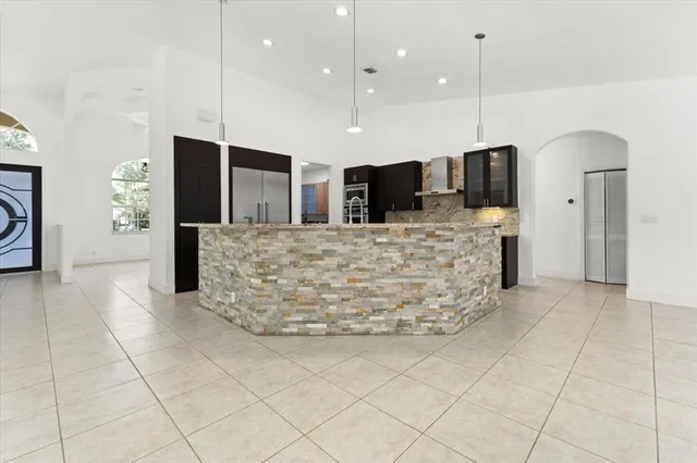 a large kitchen with kitchen island granite countertop a large oven a counter top space and stainless steel appliances