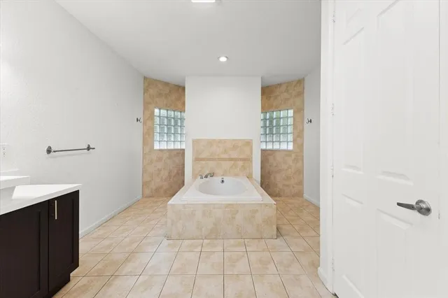 a bathroom with a bathtub sink and mirror