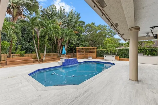 a view of house with swimming pool and sitting area