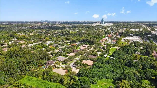 an aerial view of residential houses with outdoor space and trees