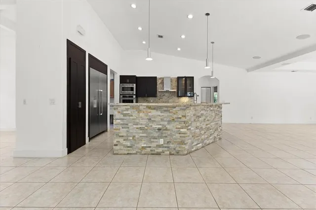 a view of a kitchen with kitchen island a counter top space appliances and cabinets