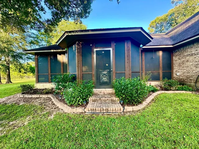 a view of brick house with a yard