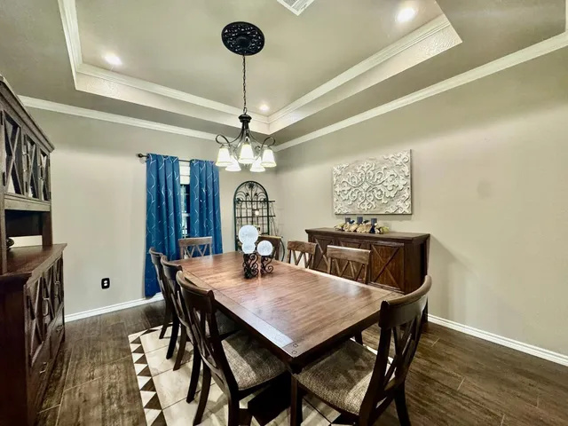 a view of a dining room with furniture a chandelier and wooden floor