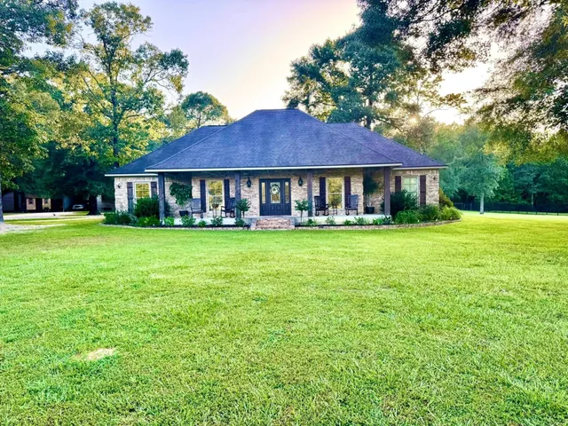 a view of a house with a yard and sitting area