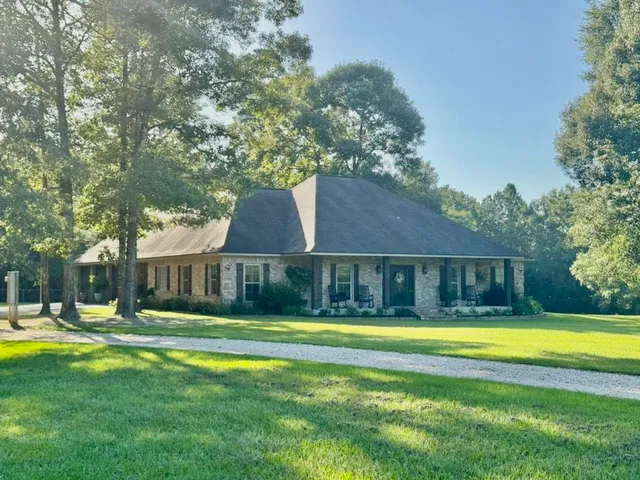 a front view of a house with swimming pool and yard