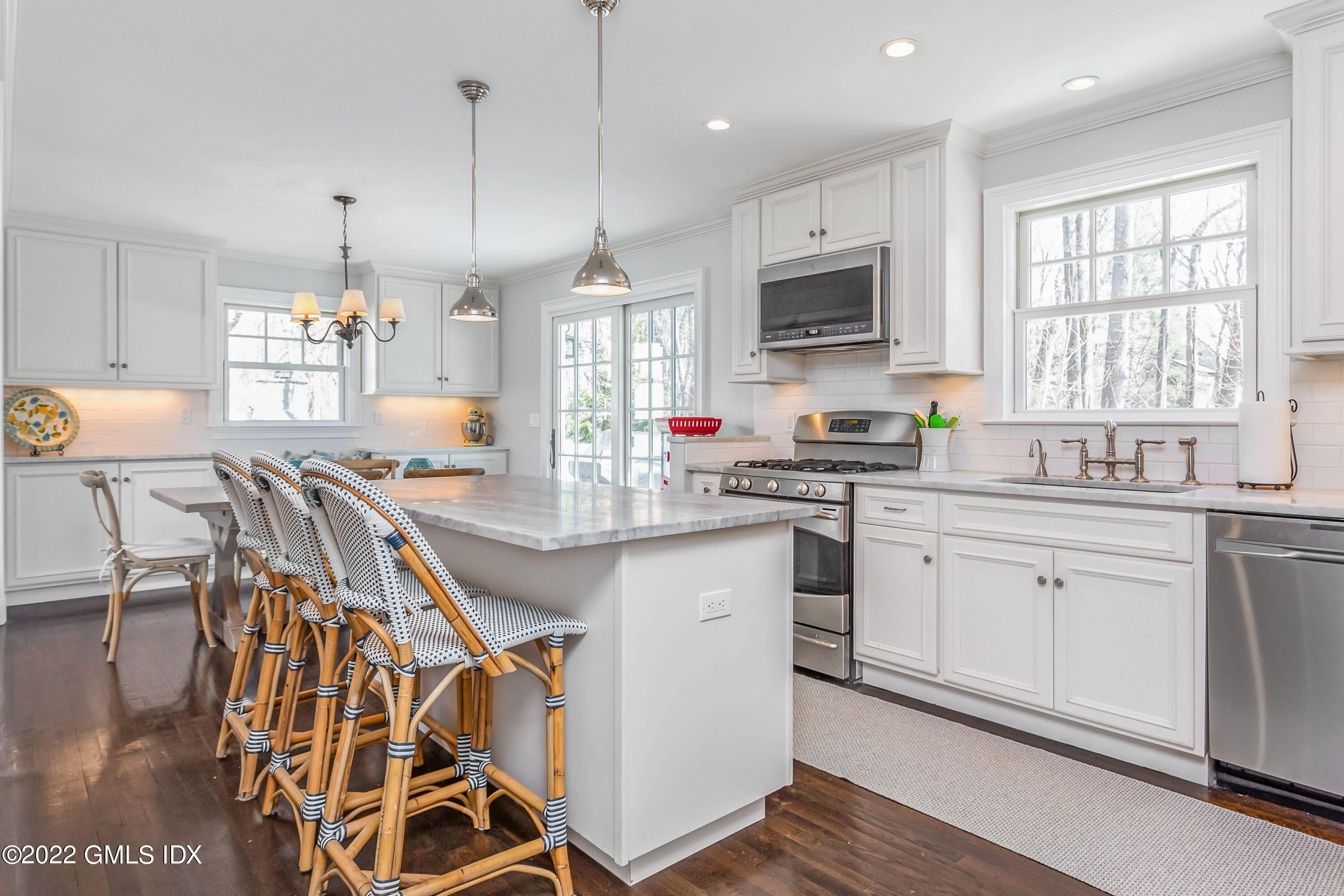 15 Dialstone Lane Riverside, CT 06878 - Photo 7 of 33 a kitchen with stainless steel appliances granite countertop a stove a sink dishwasher a microwave oven a stove with white cabinets and wooden floor