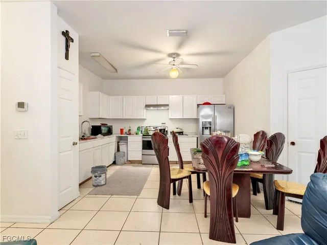 a kitchen with a dining table chairs and cabinets