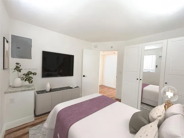 a bedroom with a bed and a flat screen tv