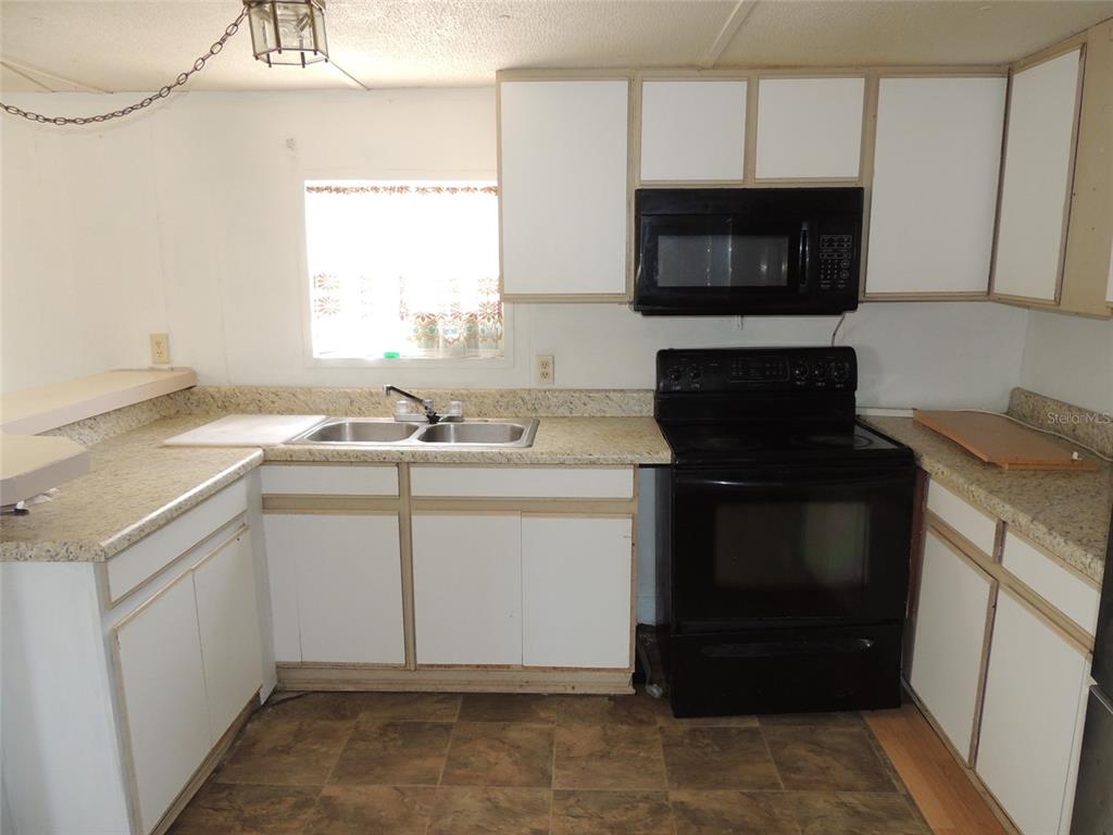 10231 Northeast 87 Place Bronson, FL 32621 - Photo 11 of 17 a kitchen with a sink stove and microwave