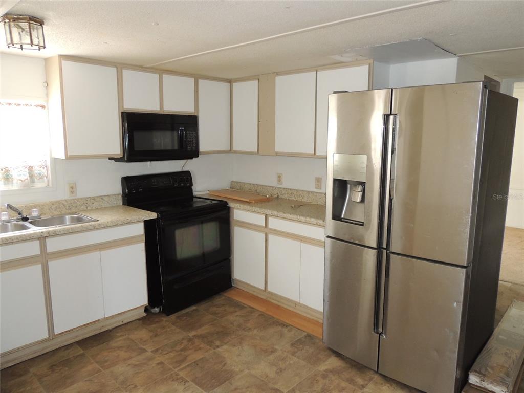10231 Northeast 87 Place Bronson, FL 32621 - Photo 10 of 17 a kitchen with a refrigerator stove and sink
