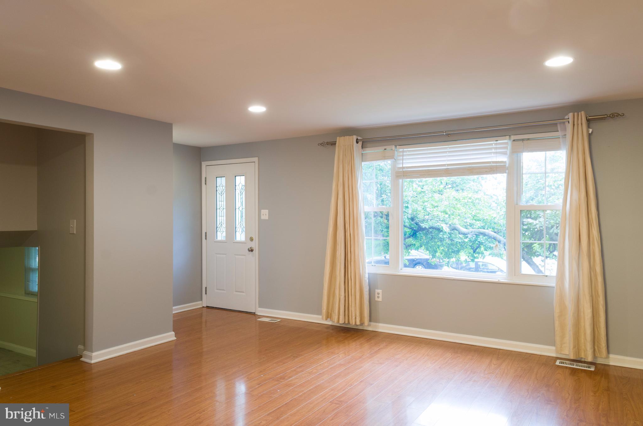 19117 Staleybridge Road Germantown, MD 20876 - Photo 3 of 19 a view of an empty room with wooden floor and a window