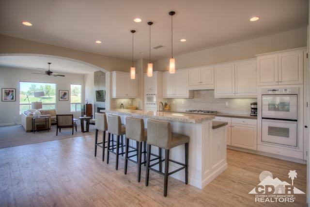 374 Loch Lomond Road Rancho Mirage, CA 92270 - Photo 4 of 38 a kitchen with lots of counter space dining table and stainless steel appliances