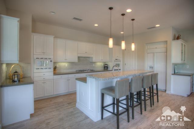 374 Loch Lomond Road Rancho Mirage, CA 92270 - Photo 5 of 38 a kitchen with kitchen island granite countertop a table and chairs in it