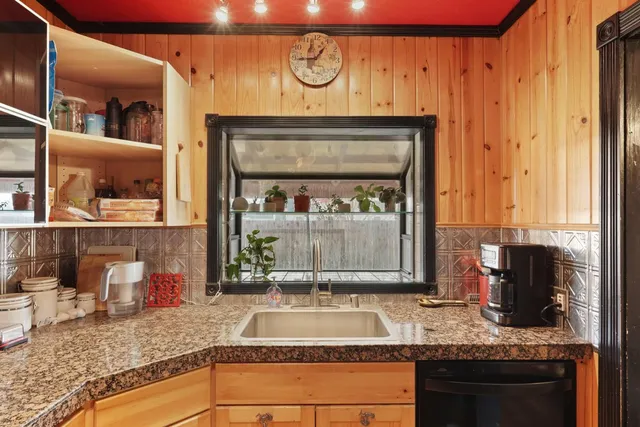 a bathroom with granite countertop a sink and a mirror