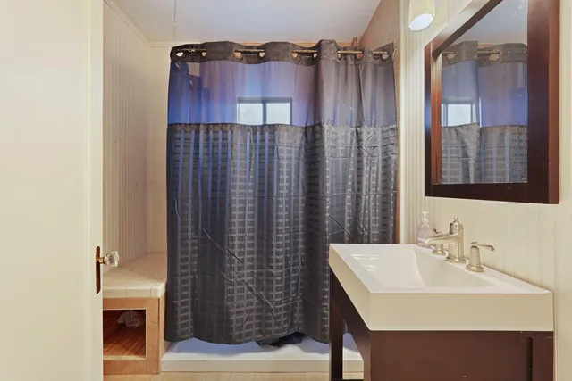 a bathroom with a sink a mirror and a shower