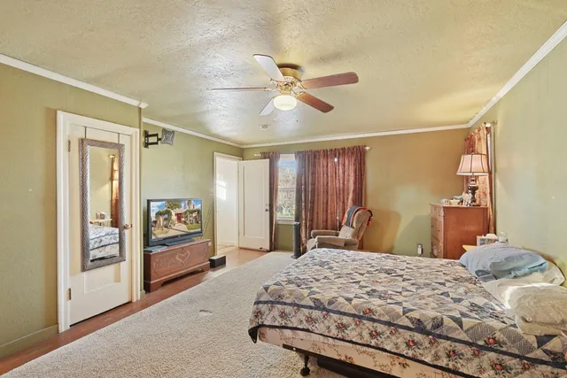 a bedroom with a large bed and a chandelier