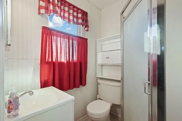 a bathroom with a sink a toilet and shower curtain