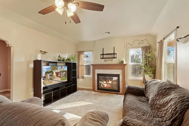 a living room with furniture a flat screen tv and a fireplace