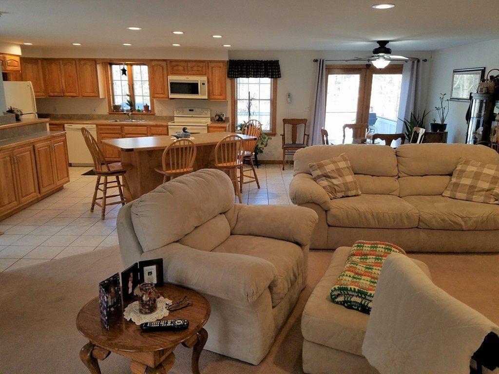52 School House Road Groton, MA 01450 - Photo 24 of 27 a living room with furniture kitchen view and a large window