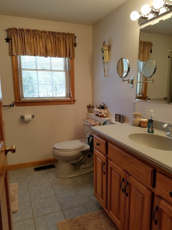52 School House Road Groton, MA 01450 - Photo 27 of 27 a bathroom with a sink a toilet and mirror