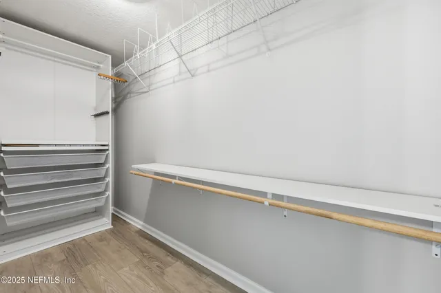 a view of walk in closet with empty racks