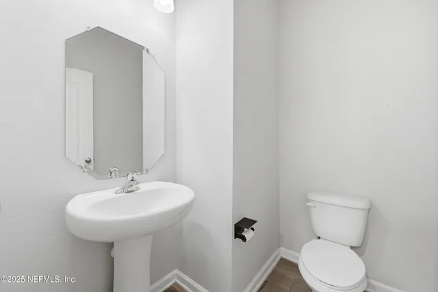 a bathroom with a toilet sink and mirror
