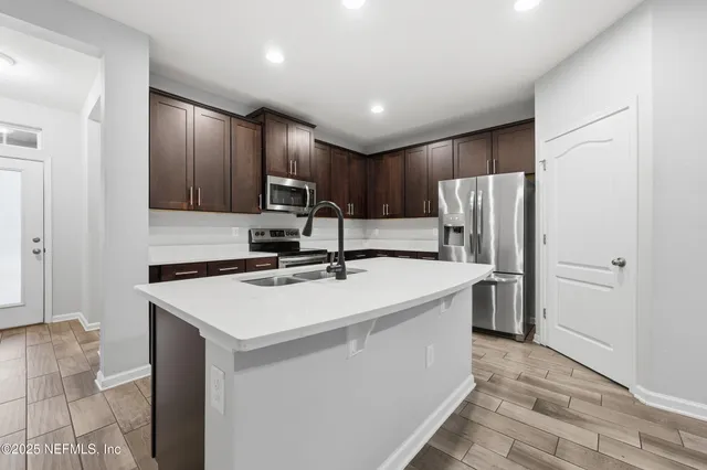 a kitchen with kitchen island a sink appliances and cabinets