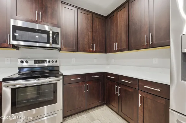 a kitchen with wooden cabinets and stainless steel appliances
