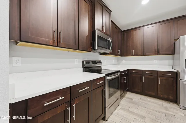 a kitchen with stainless steel appliances granite countertop a sink stove and microwave