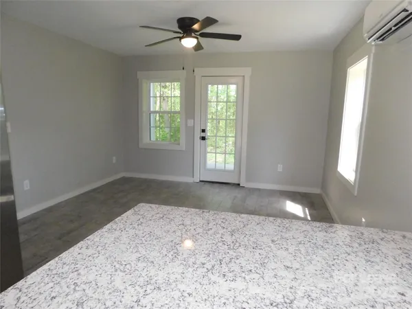 a view of a big room with windows and chandelier fan