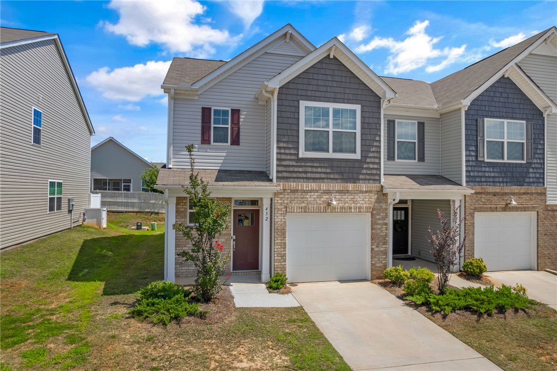 432 Bee Cv Way Pendleton, SC 29670 - Photo 3 of 39 This charming townhome features a brick and siding facade, offering convenient front-facing garage access.