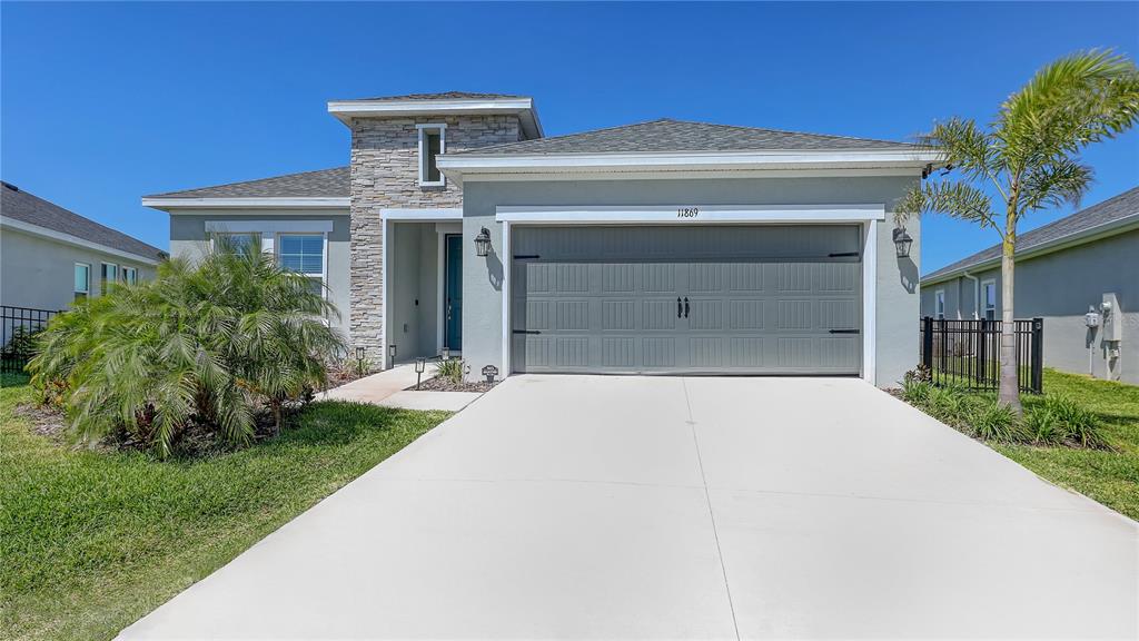 11869 Richmond Trail Parrish, FL 34219 - Photo 1 of 68 a front view of a house with a yard and garage
