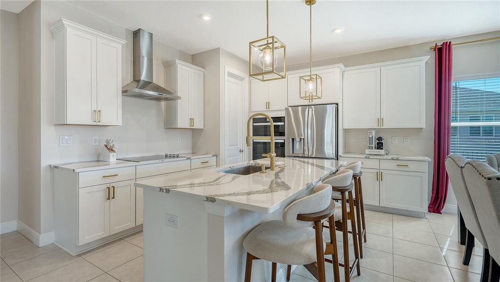 11869 Richmond Trail Parrish, FL 34219 - Photo 11 of 68 a kitchen with stainless steel appliances kitchen island granite countertop a sink a stove a refrigerator and island with wooden floor